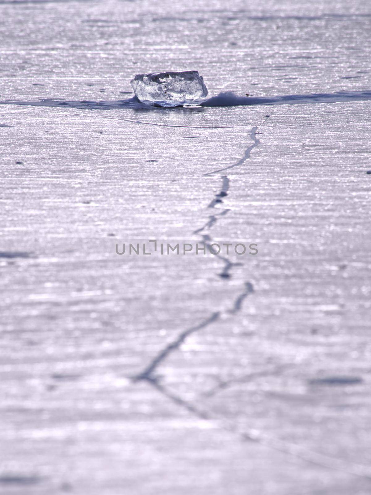 Shards of cracked ice jut out on the frozen lake. The light phenomenon occurs around a very specific time of year