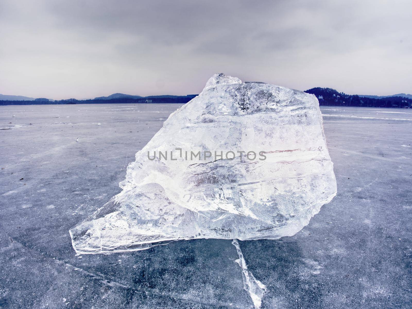 Arctic ice. A large piece of natural ice on a green blue flat ice of frozen lake by rdonar2