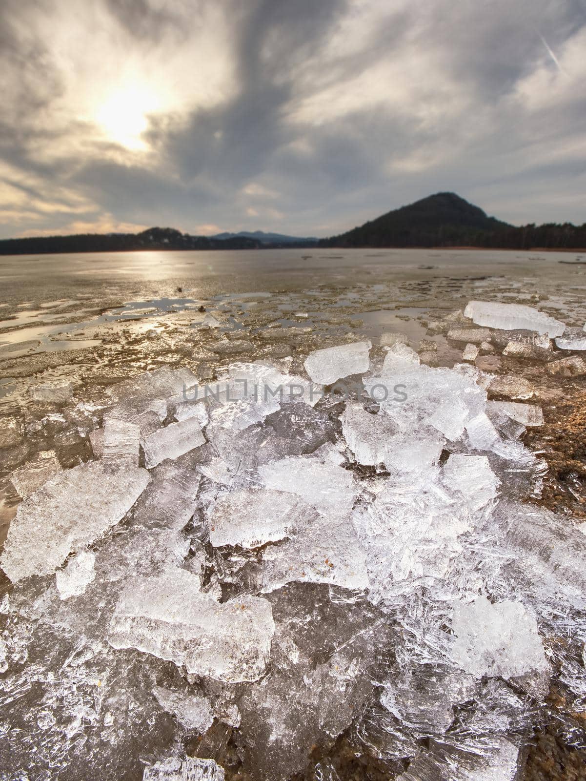 Pieces of clear natural ice on frozen lake,  very close up view. Early mealting of ice by rdonar2