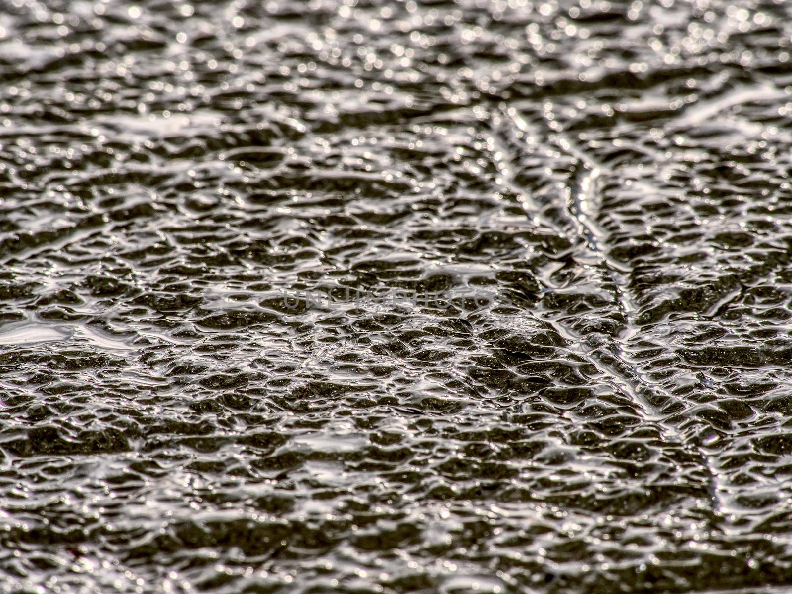 Cracked glacier ice in close-up detail. Natural ice pattern structure with natural baackground. Winter detail