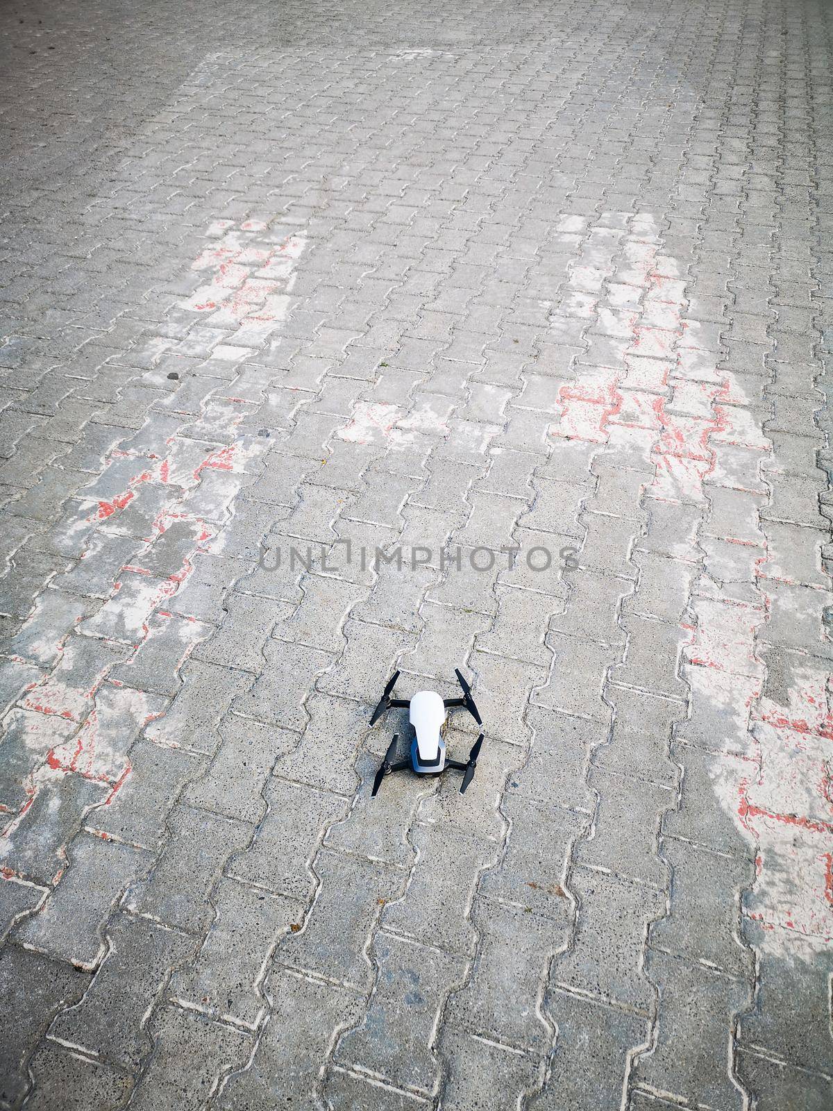 Small white drone on big H on helipad by Wierzchu