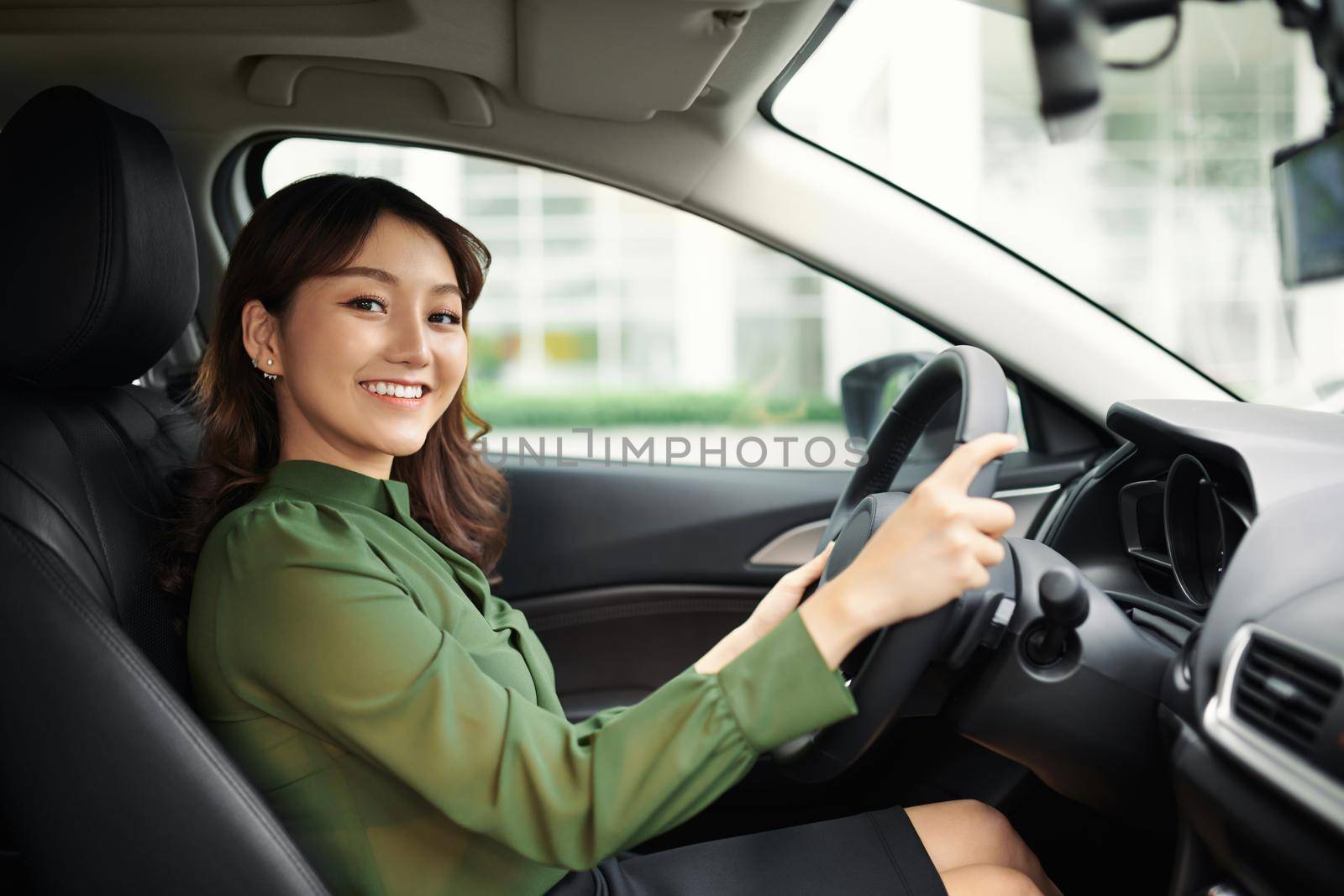 Alluring young woman driving the car and smiling