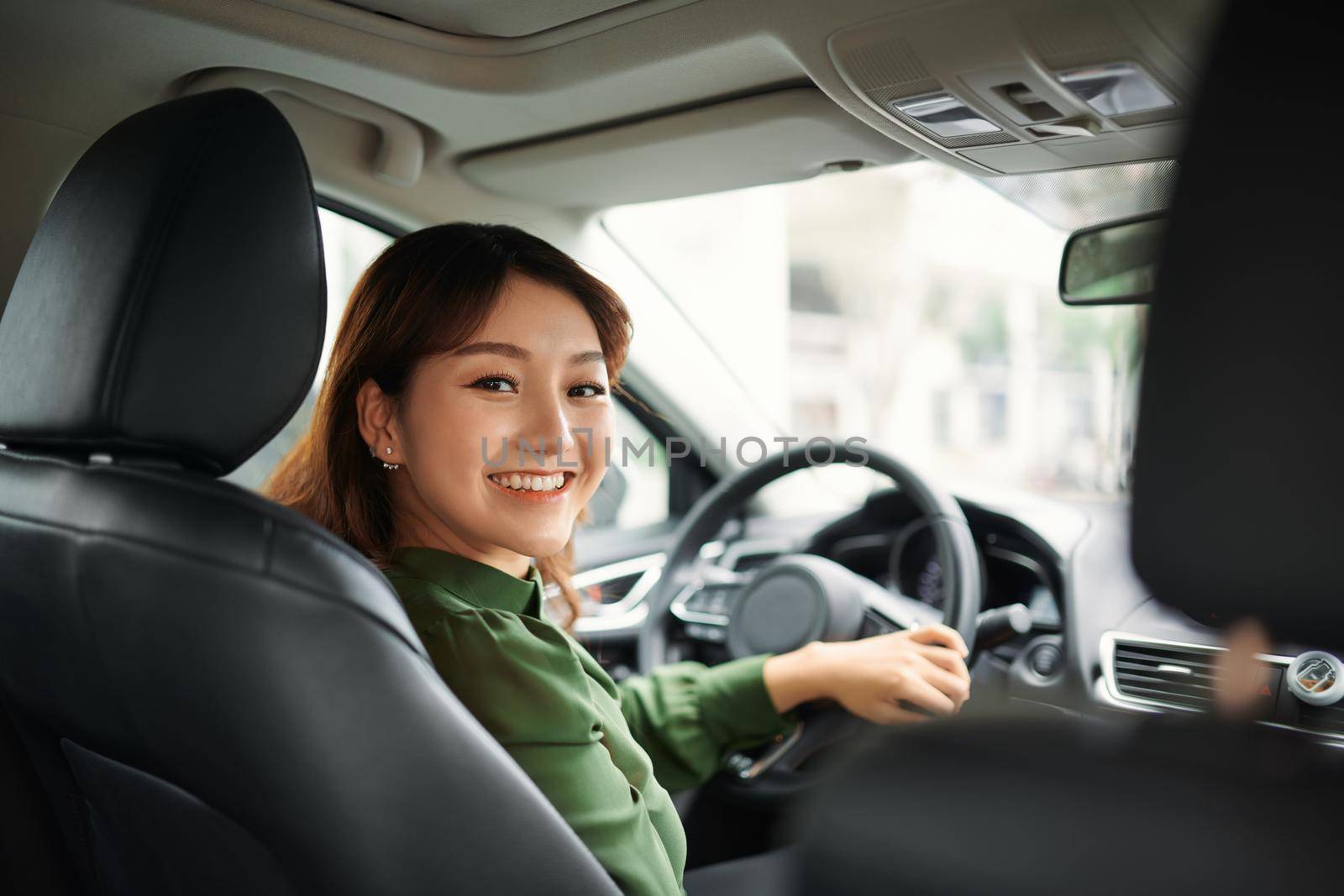 Pretty businesswoman smiling and driving in her car