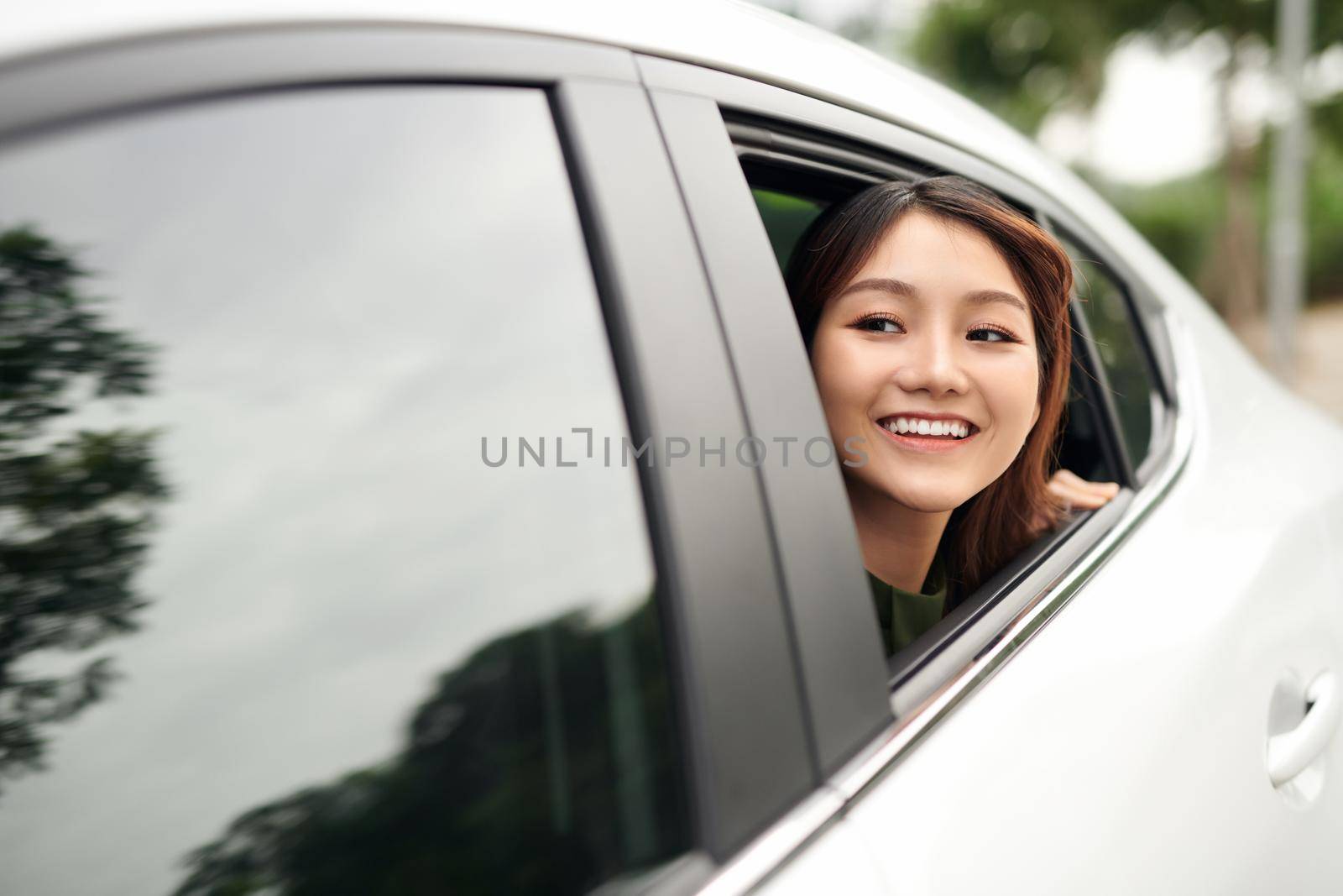 Woman in car. Beautiful young woman looking out from a car and looking at camera