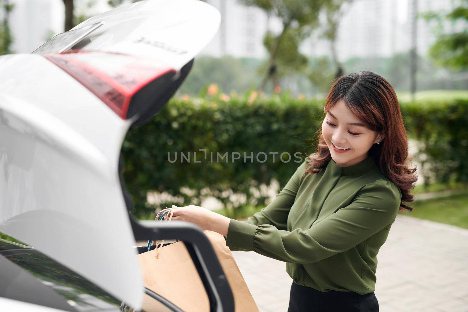 beautiful girl with shopping bags near a her car