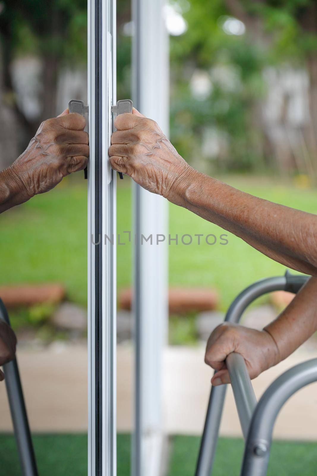 Elderly woman with key opening front door.