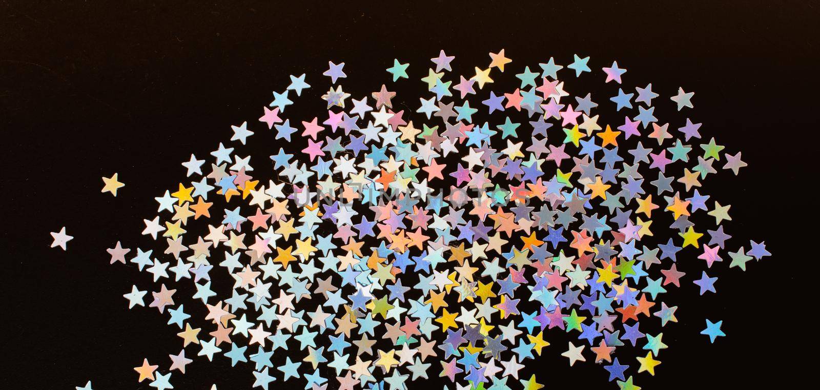 Colorful confetti stars on a dark color background by berkay