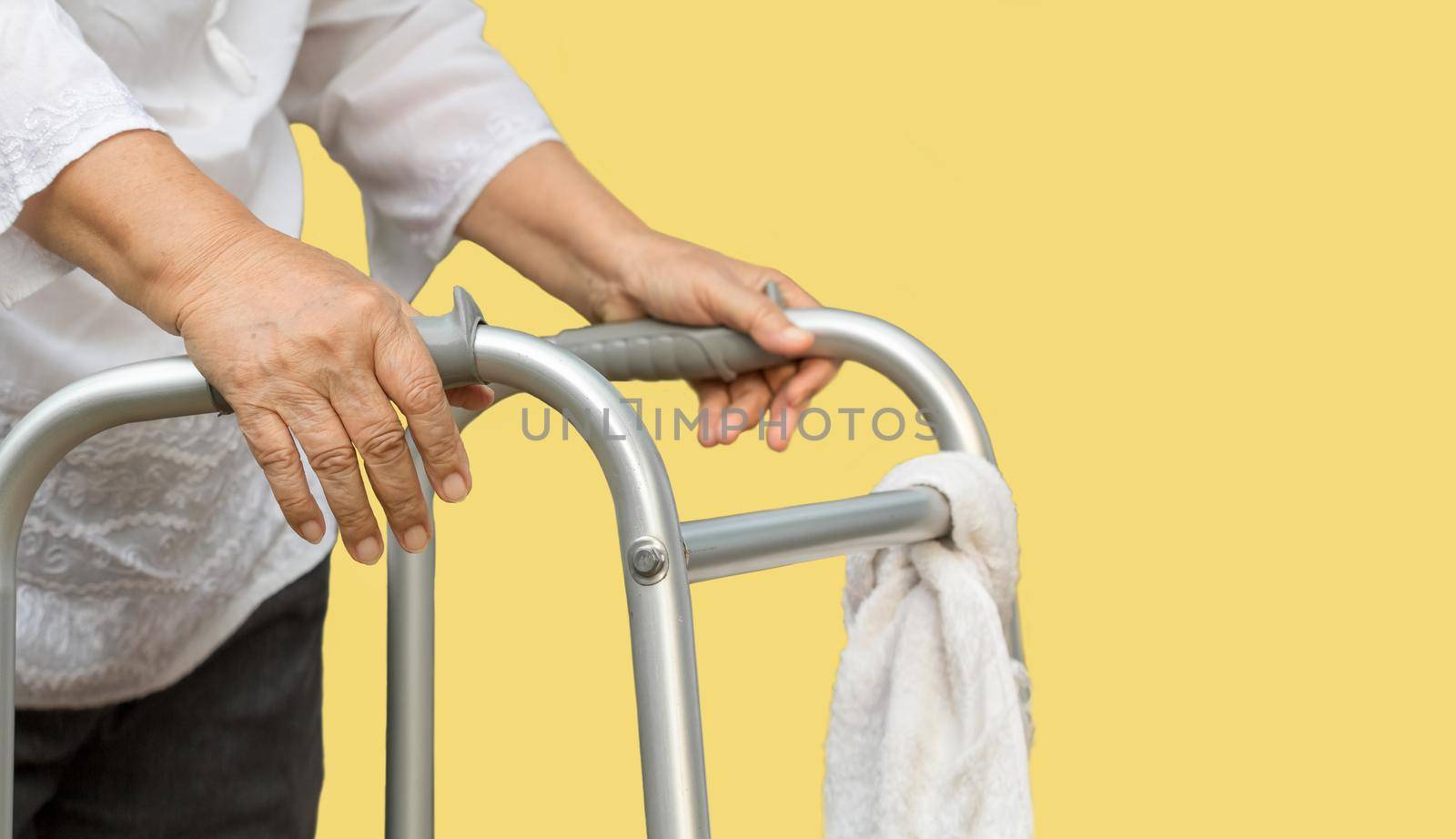 senior woman using a walker cross street with caregiver