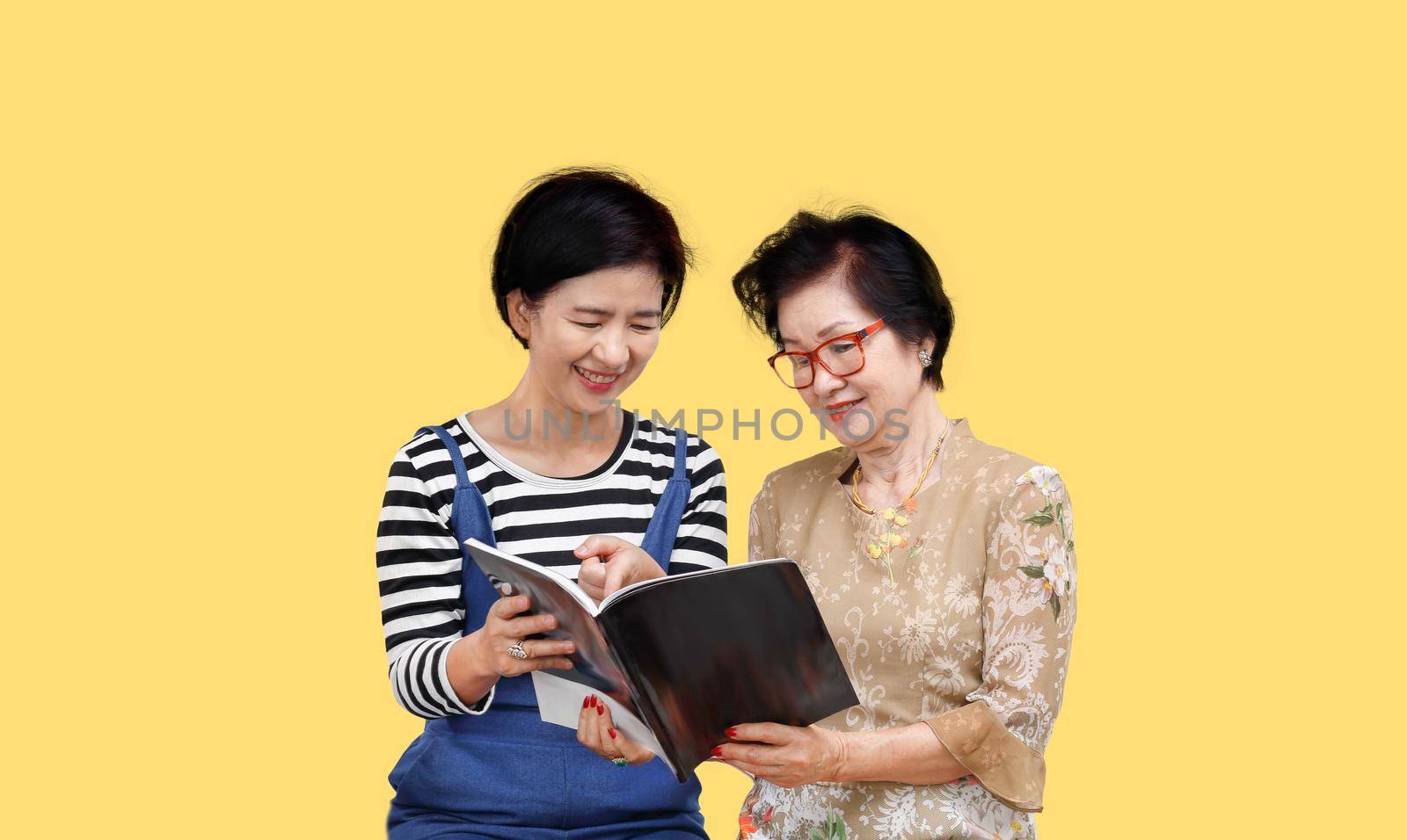 Senior woman reading a magazine with her daughter