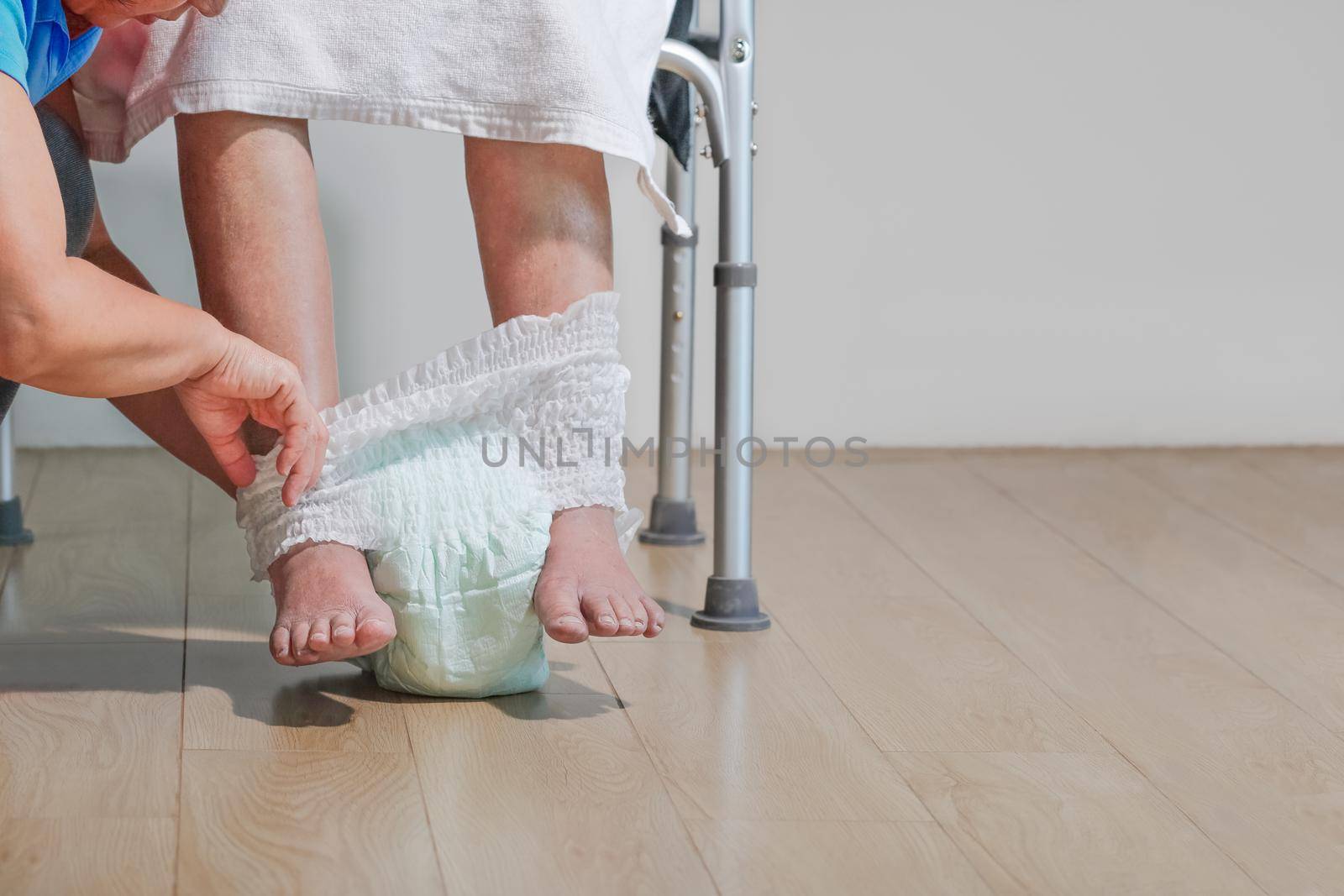 elderly woman changing diaper with caregiver