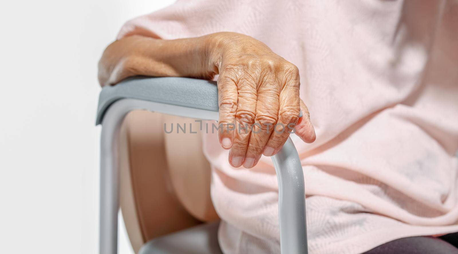 Elderly woman using mobile toilet seat chair