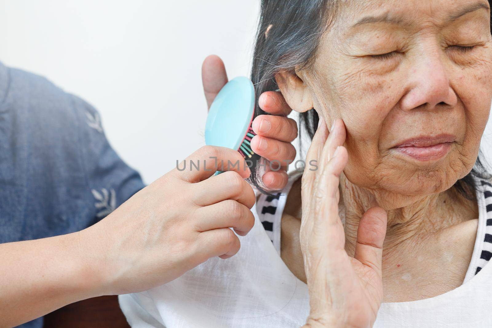 elderly woman combing hair by caregiver by toa55