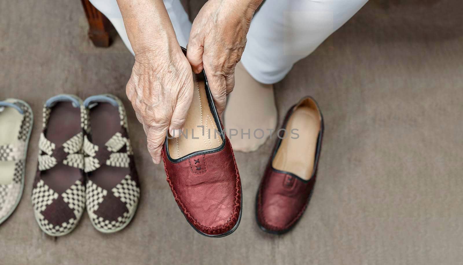 Elderly woman putting on shoes by toa55