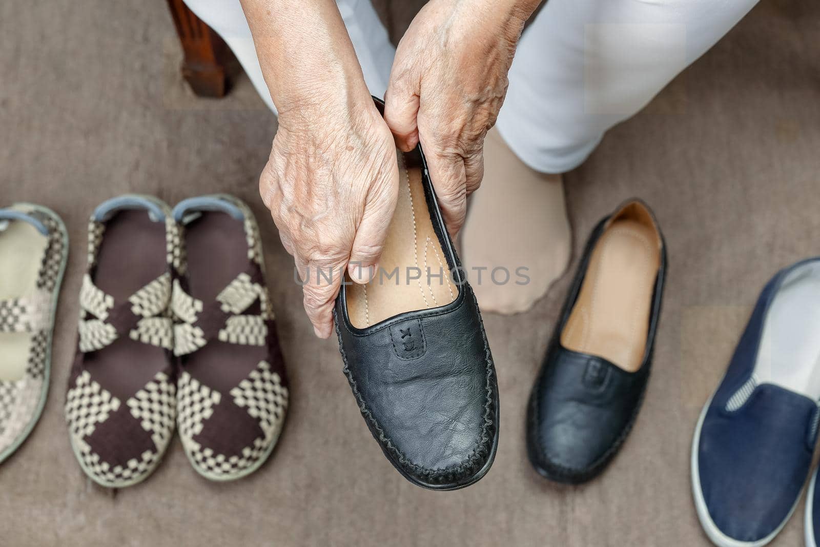 Elderly woman putting on shoes by toa55