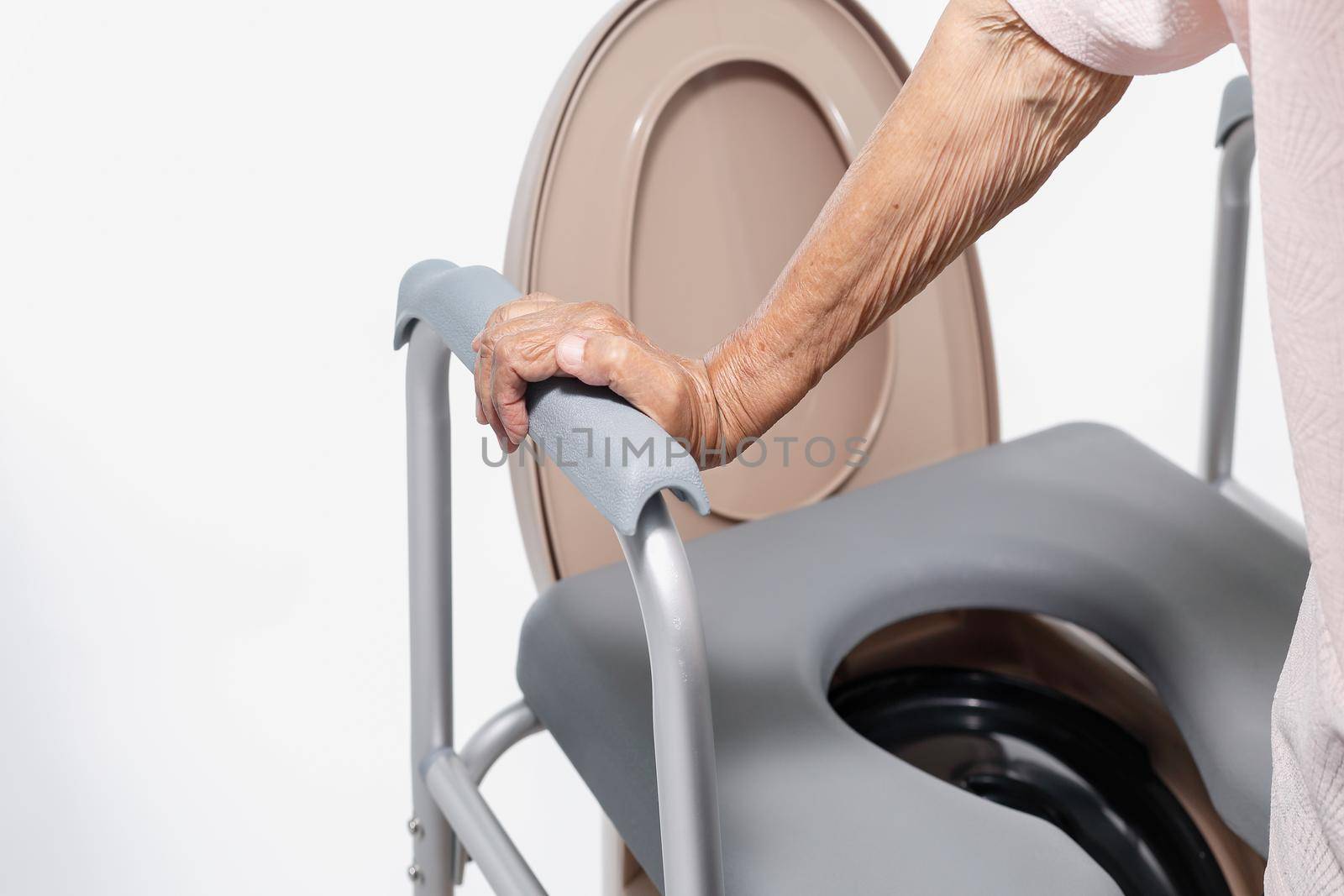 Elderly woman using mobile toilet seat chair