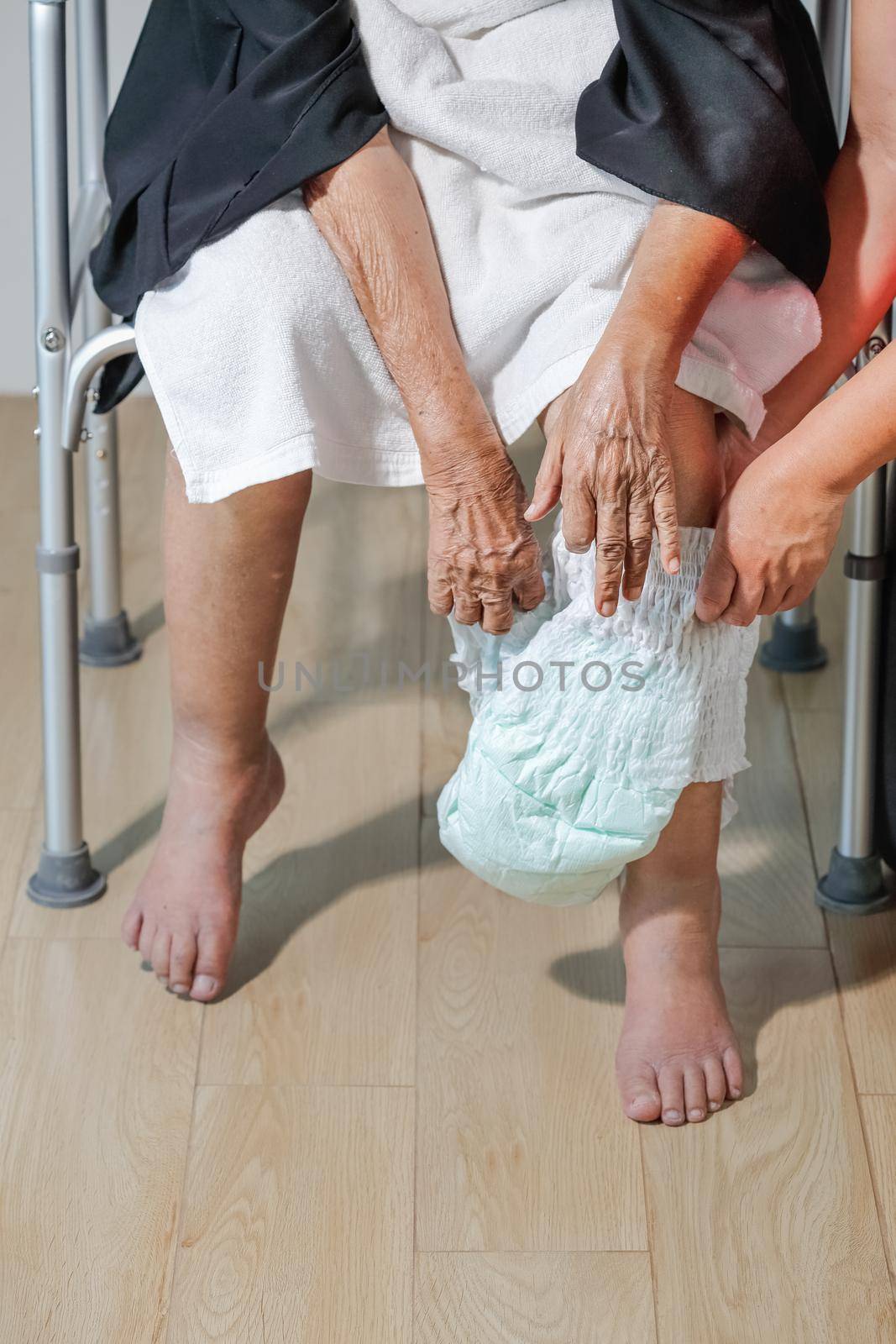 elderly woman changing diaper with caregiver by toa55