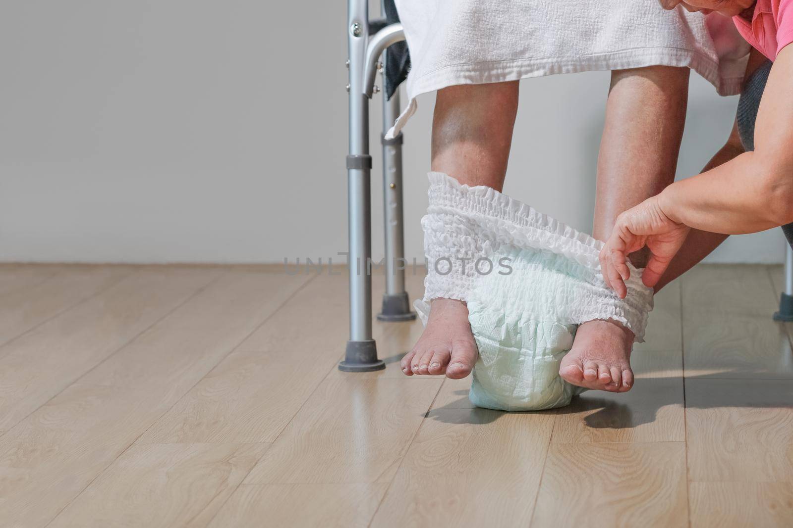 elderly woman changing diaper with caregiver