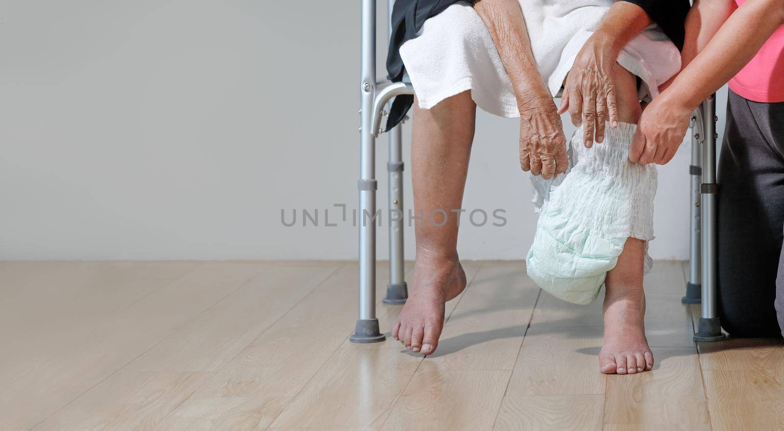 elderly woman changing diaper with caregiver