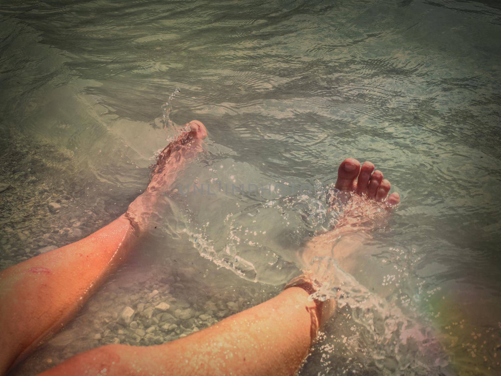 Naked legs stay on gentle gravel in water of carabbien sea.  Abstract.