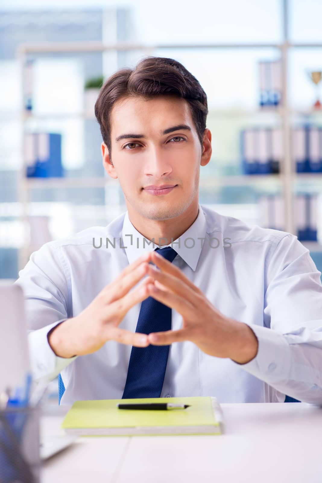 Young handsome businessman employee working in office at desk