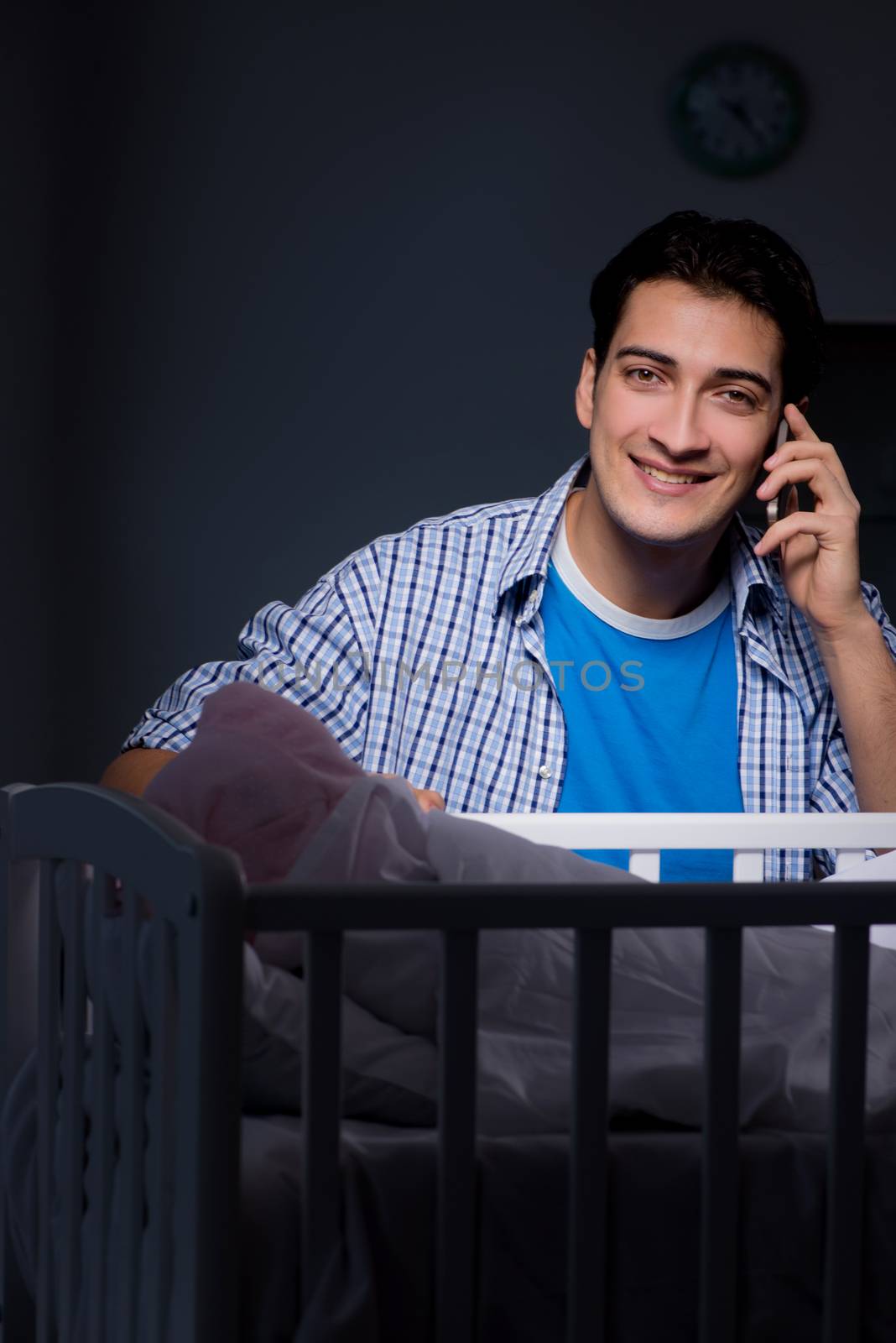 Happy dad looking after newborn baby at night