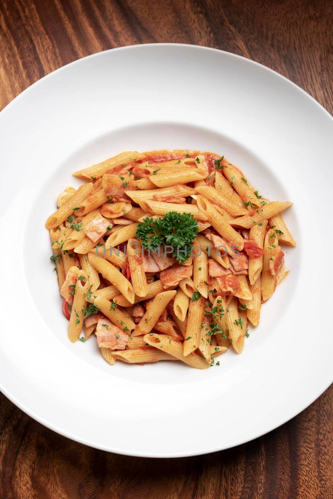 penne amatriciana tomato and ham sauce pasta on wood table background