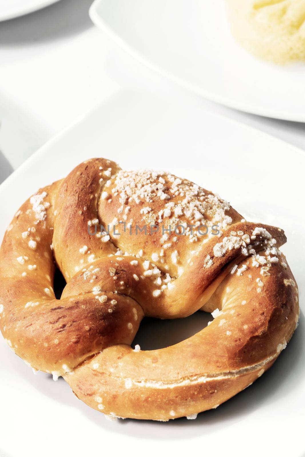 vegan dairy-free organic german pretzel bread on white table by jackmalipan
