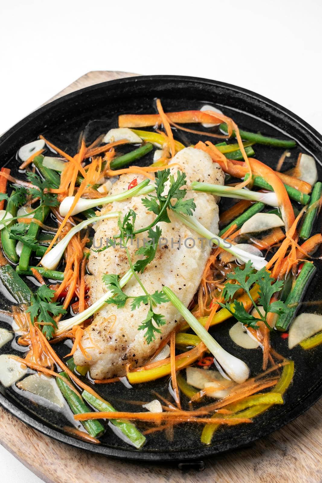 chinese cantonese style steamed spicy fish fillet with vegetables on hot plate