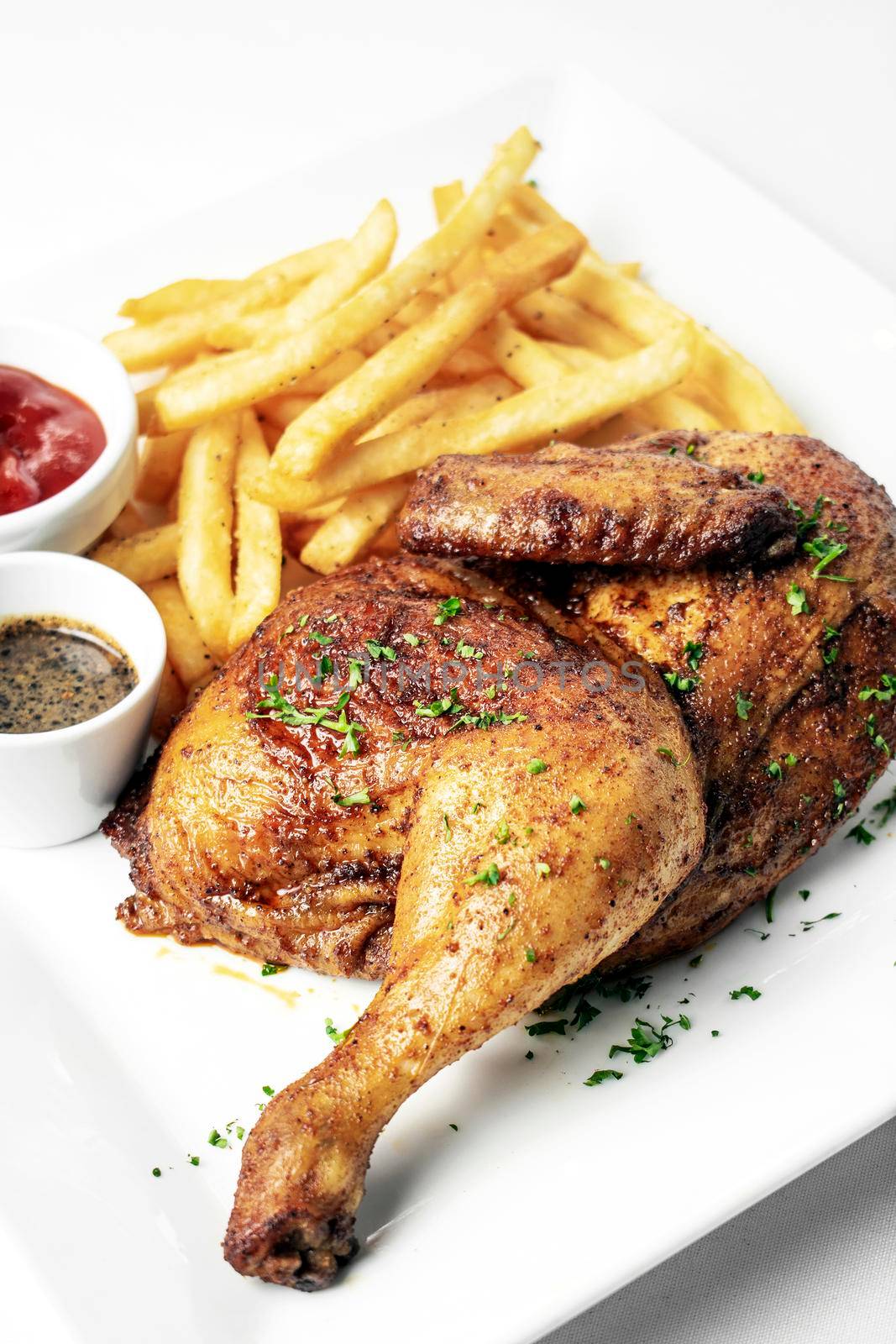 roast rotisserie half chicken with french fries simple meal on white plate