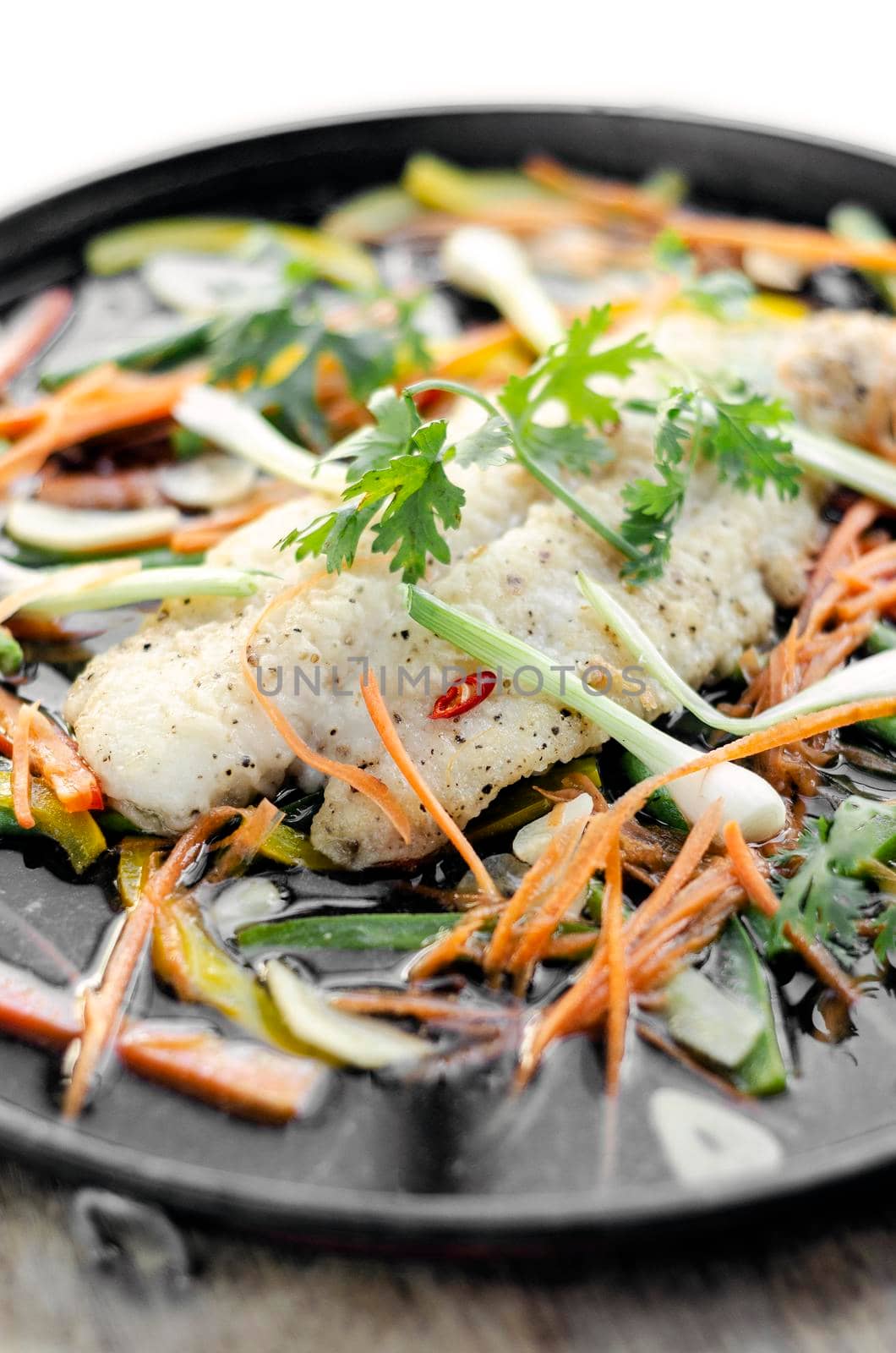 chinese cantonese style steamed spicy fish fillet with vegetables on hot plate