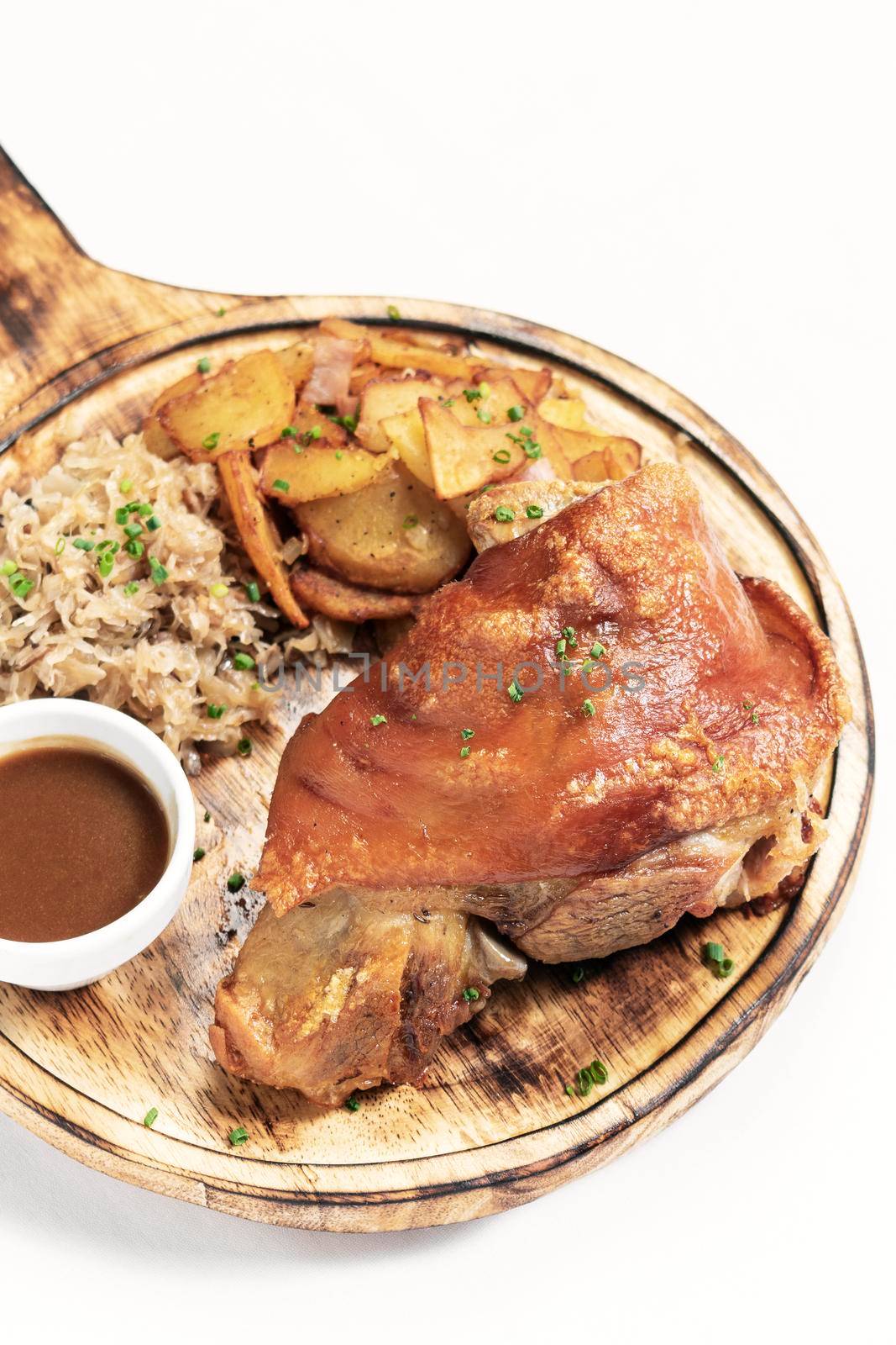 SCHWEINSHAXE traditional german pork knuckle with sauerkraut and potatoes meal on white background