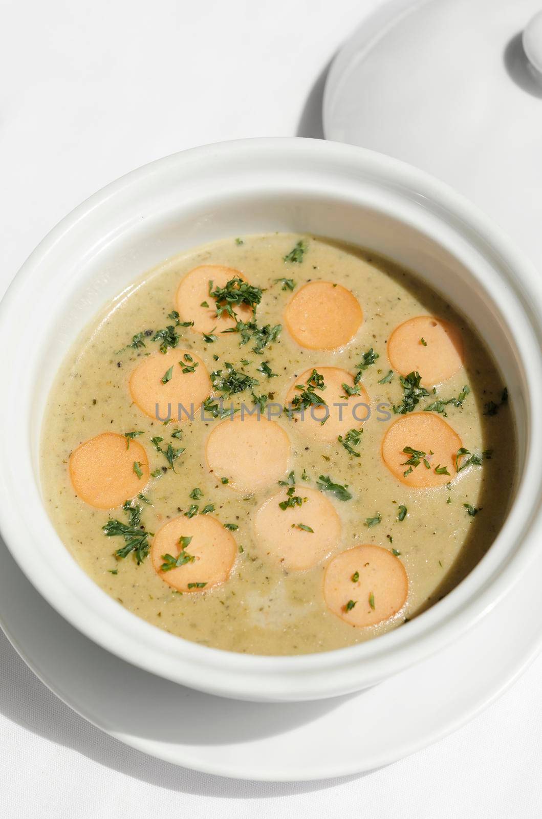 German traditional KARTOFFELSUPPE potato and sausage soup on white tabel background