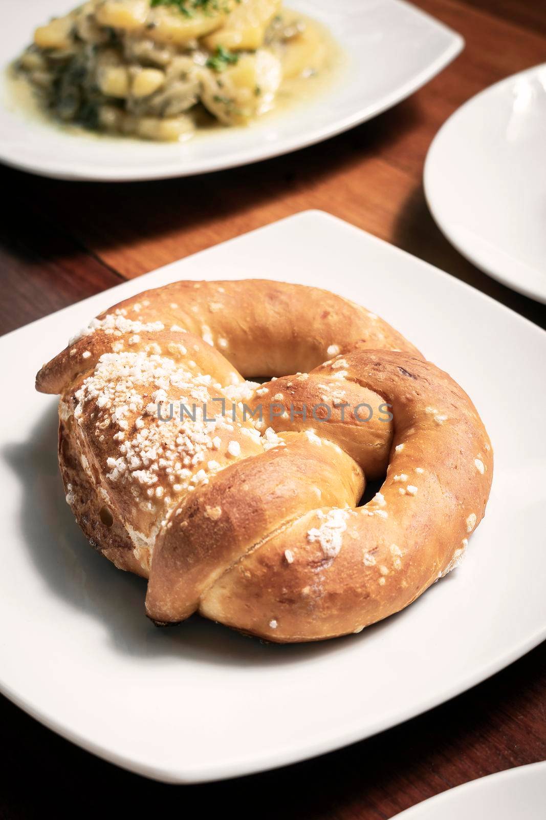 vegan dairy-free organic german pretzel bread on wood table by jackmalipan
