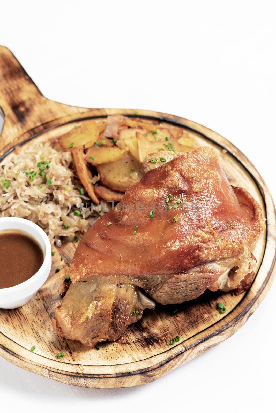 SCHWEINSHAXE traditional german pork knuckle with sauerkraut and potatoes meal on white background