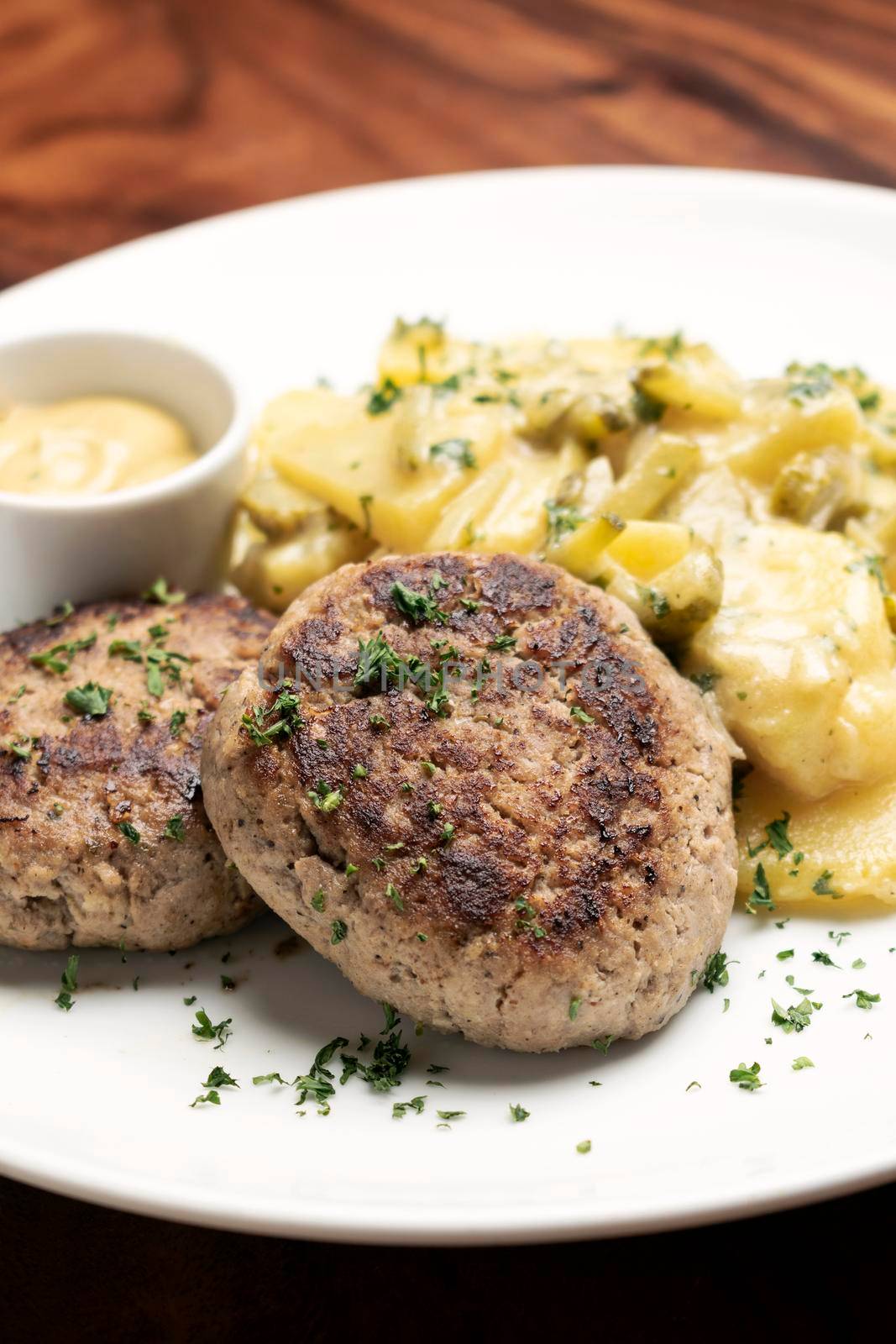 german frikadellen meatballs with creamy onion fried potatoes and mustard sauce on wood table background