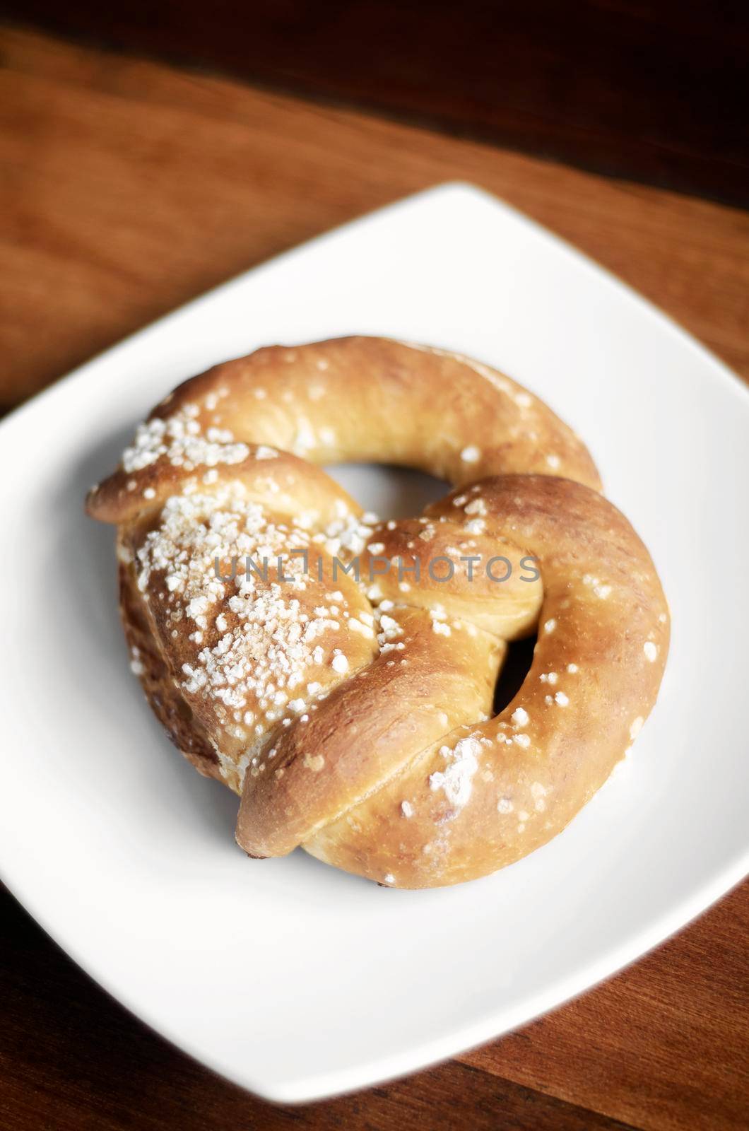 vegan dairy-free organic german pretzel bread on wood table by jackmalipan