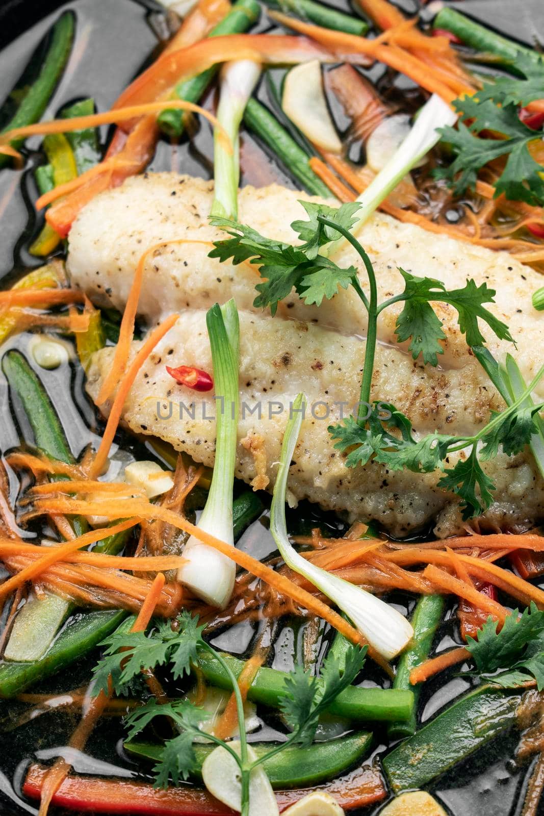 chinese style steamed fish fillet with vegetables on hot plate by jackmalipan