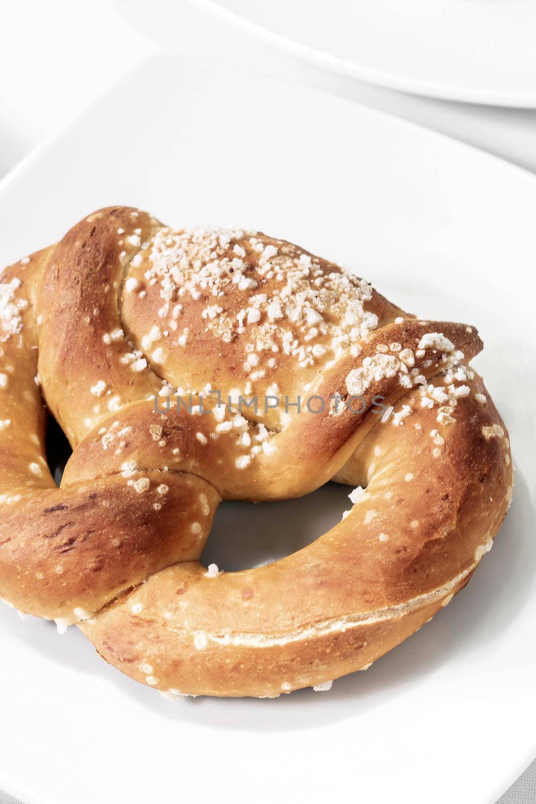 vegan dairy-free organic german pretzel bread on white table by jackmalipan