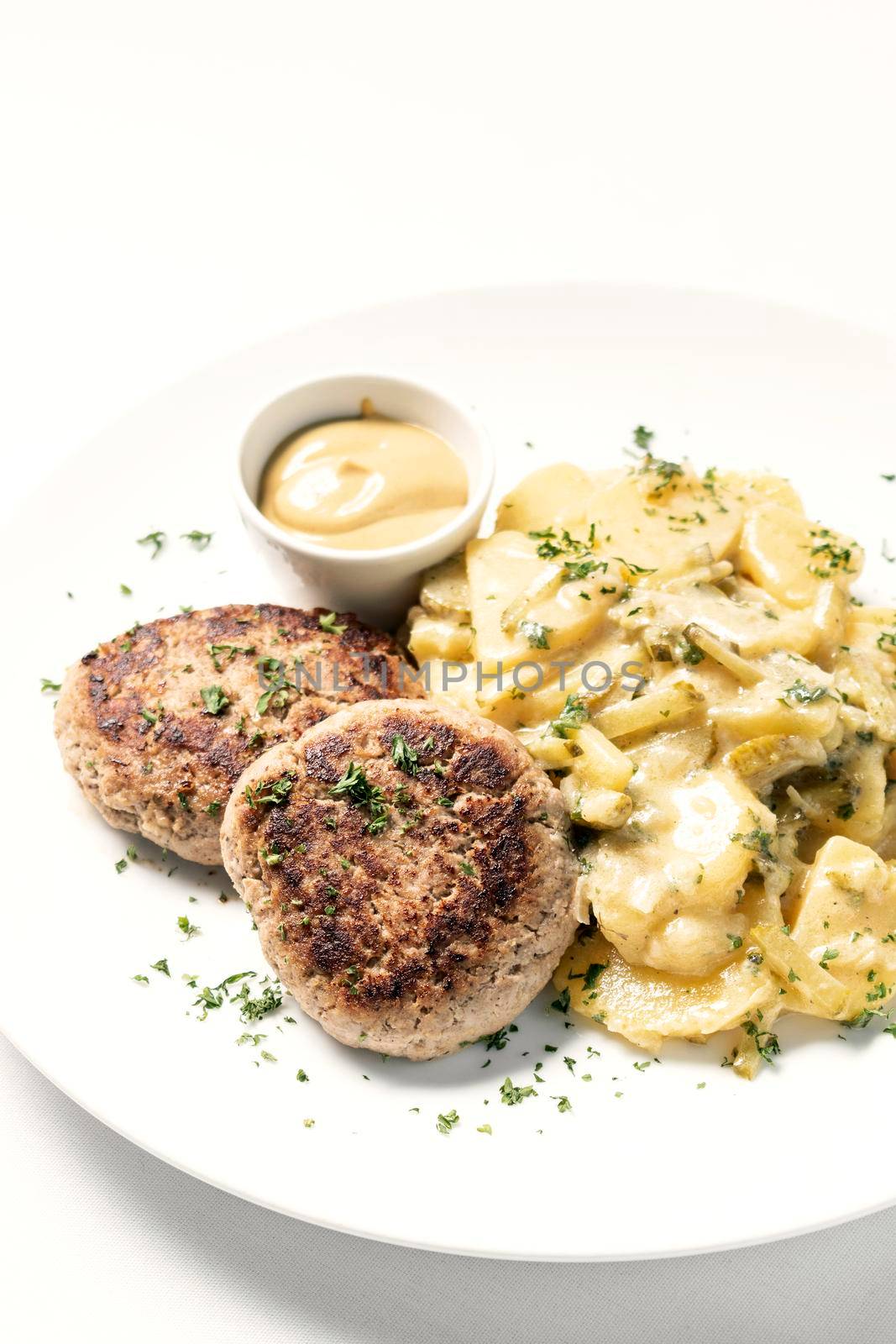 german frikadellen meatballs with creamy onion fried potatoes and mustard sauce on white background