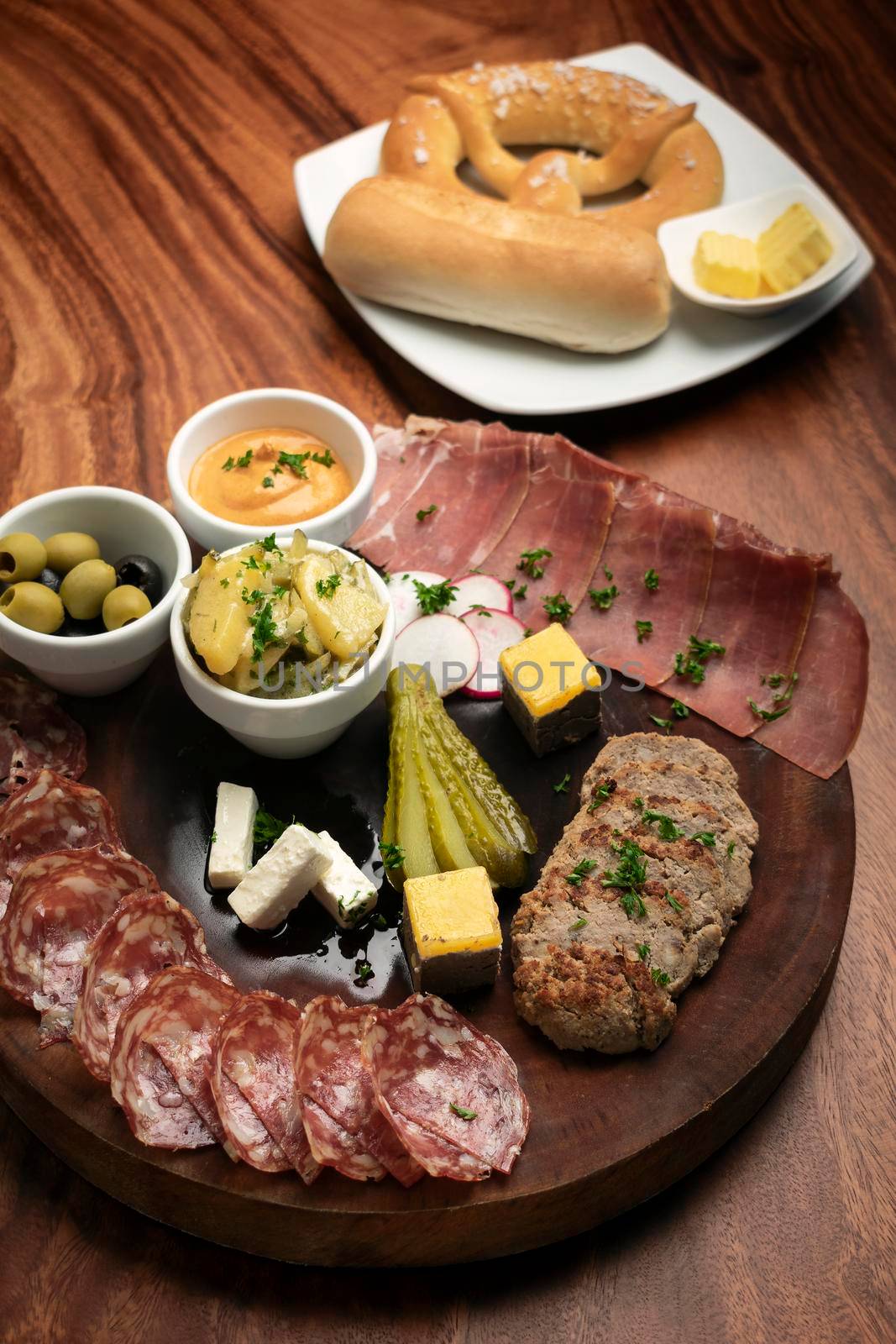 german cold cuts tapas snack platter with meats and bread on wood table background