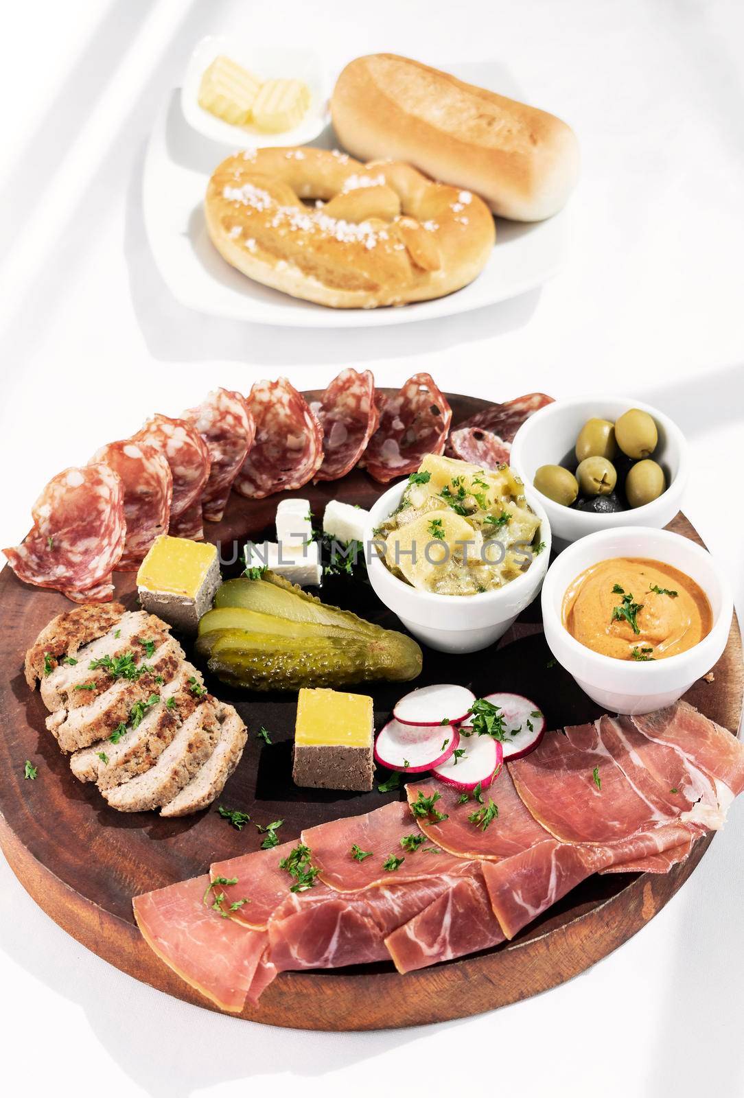 german cold cuts tapas snack platter with meats and bread on white background