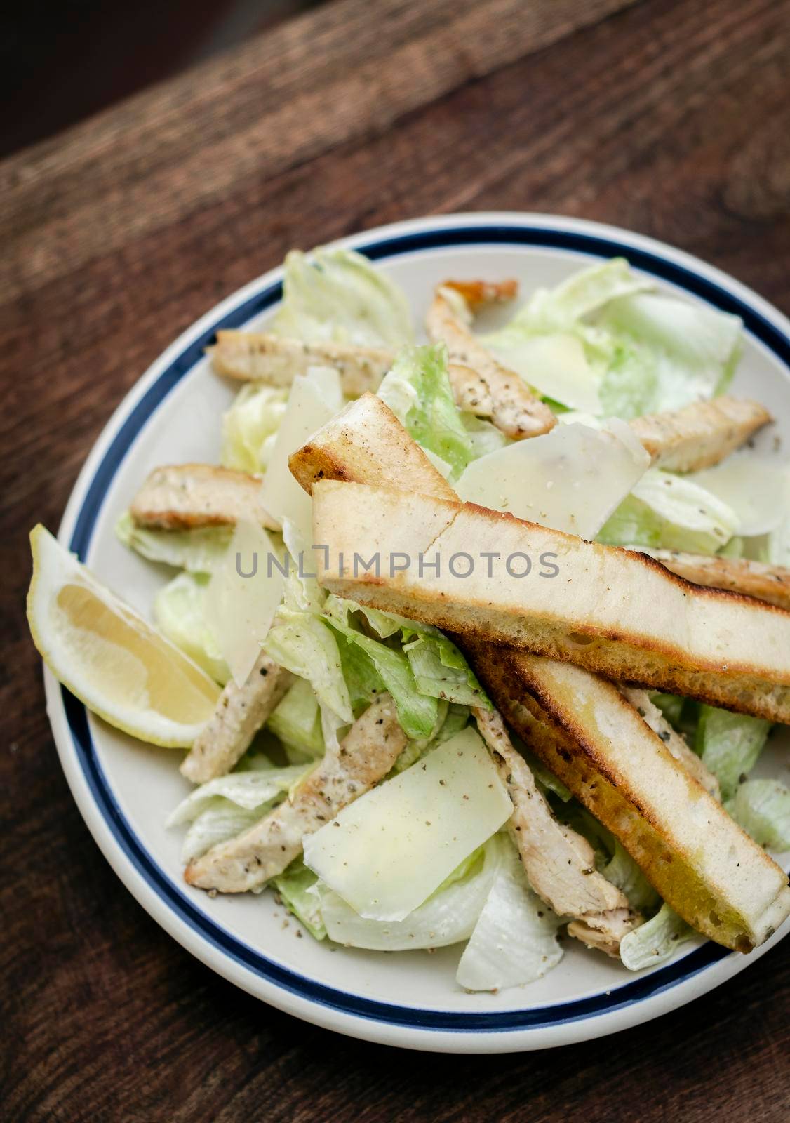 simple healthy orgaanic chicken caesar salad on wood table