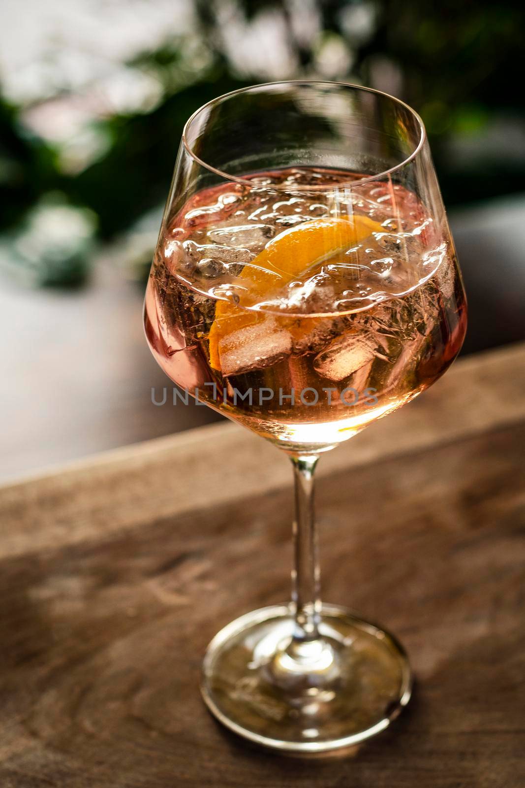 rose wine spritzer with orange cocktail drink on table outside by jackmalipan