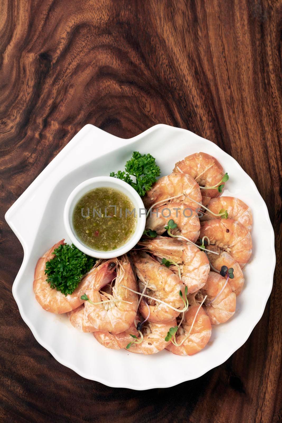 fresh boiled prawns with zesty citrus dipping sauce on wood table