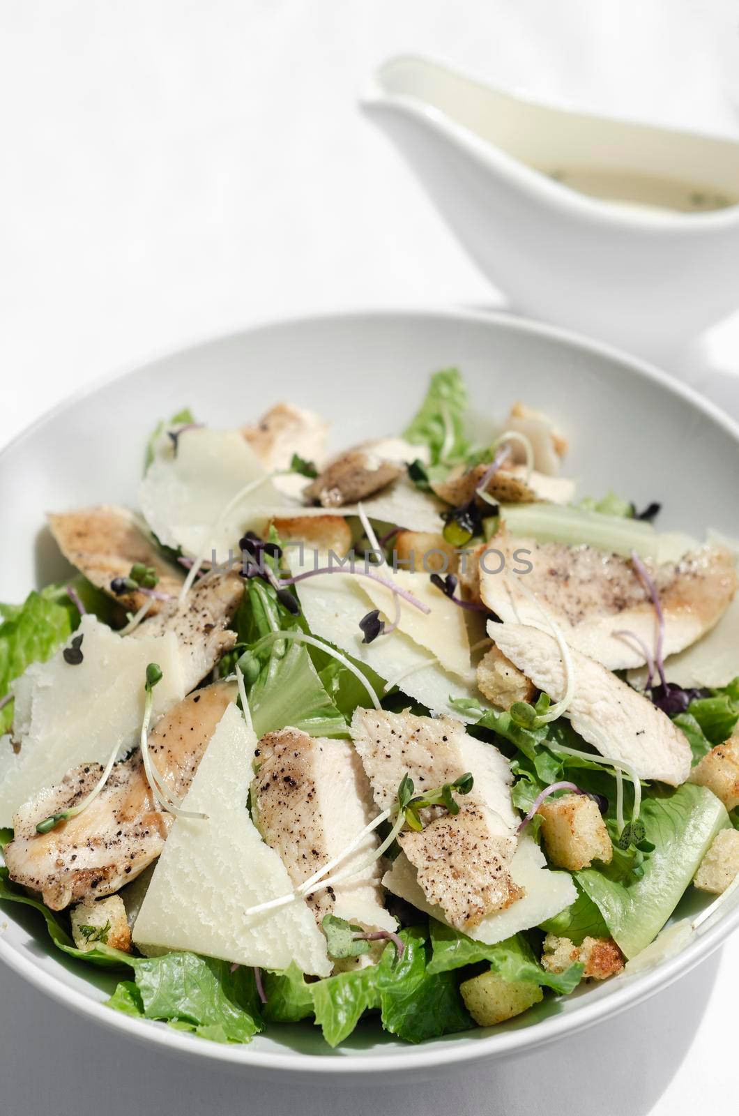 organic chicken caesar salad with parmesan cheese and croutons by jackmalipan