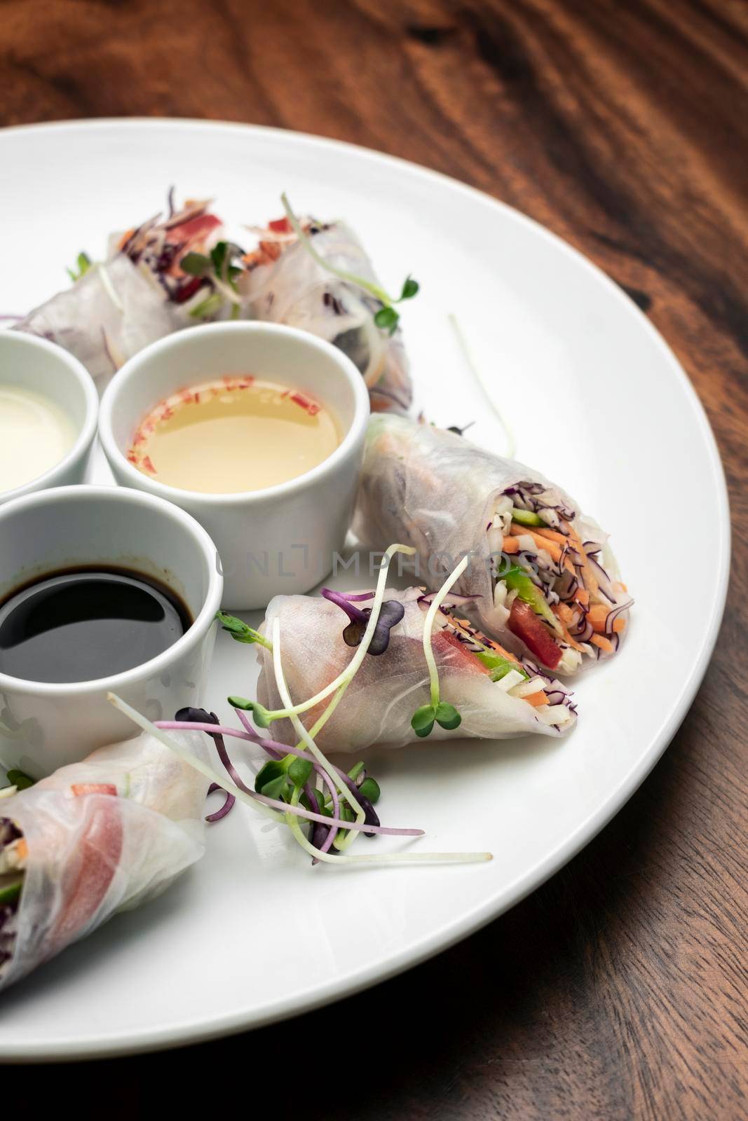 asian fresh vegetable vegan spring rolls with sauces in vietnam by jackmalipan