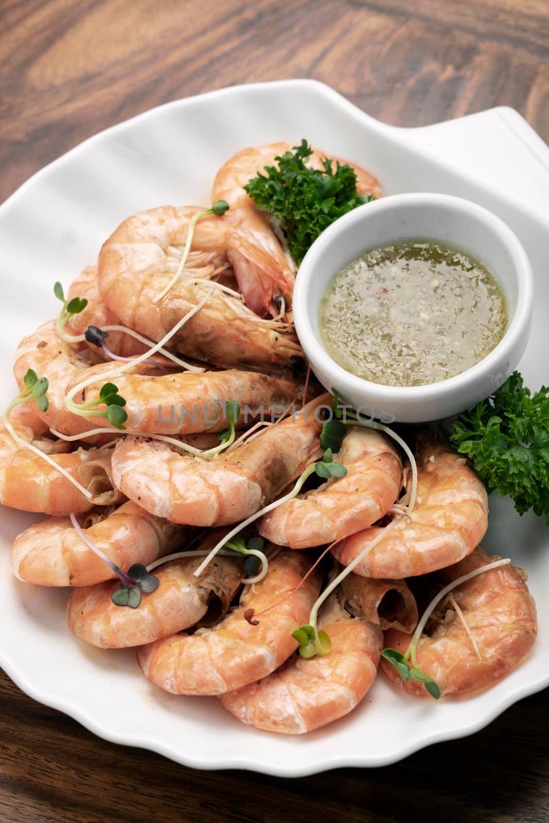 fresh boiled prawns with zesty citrus dipping sauce on wood table