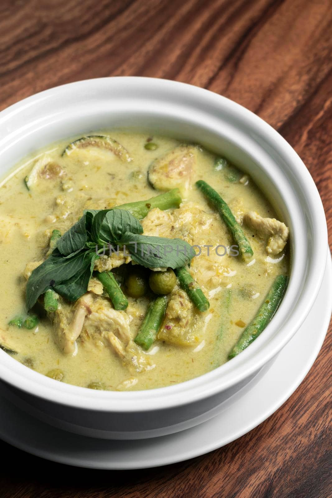 thai green curry with chicken and vegetables on wood table