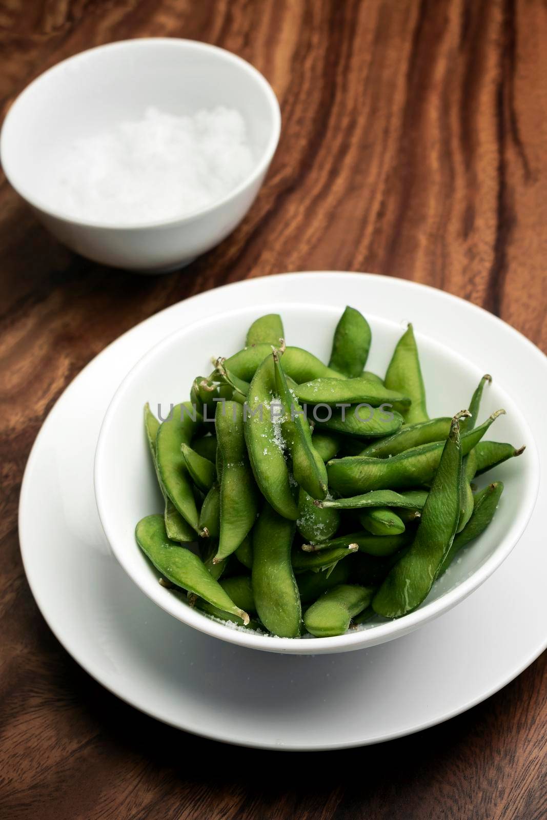 edamame beans in bowl on table with sea salt by jackmalipan