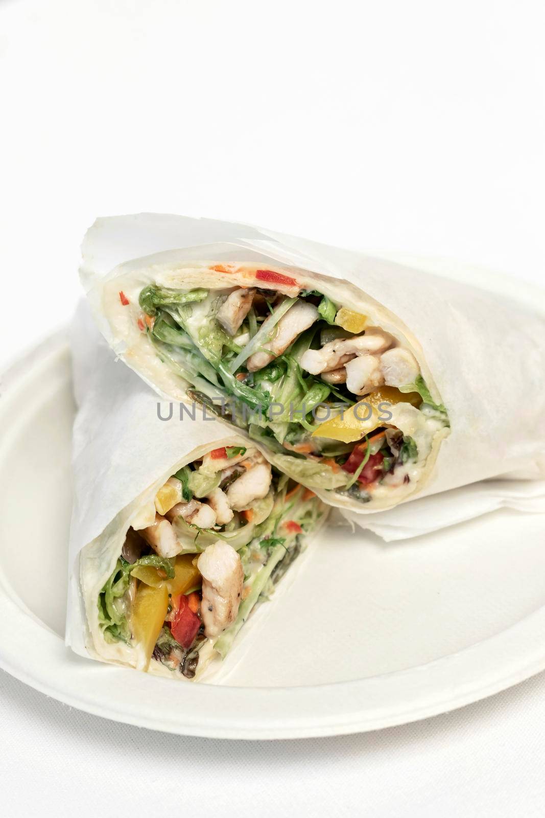 chicken salad wrap in white paper on studio background by jackmalipan